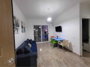 a living room with a blue couch and a table at JL apartament tirana resort in Radhimë