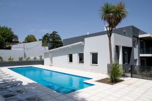 una piscina frente a una casa con una palmera en Amore Lhirondelle 1, en La Falda