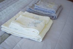 two towels sitting on top of a bed at Villa Casa Carlotti in Ponte de Vagos +30 photos
