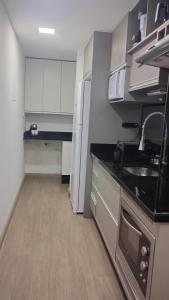 a small kitchen with a sink and a refrigerator at Apartamento completo B51,com ar condicionado,400 m do centro in Mogi das Cruzes