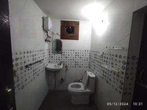une salle de bain avec toilettes et lavabo dans l'établissement Brij Lok Dhaam 89792sham16956, à Mathura