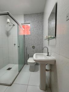a bathroom with a toilet and a sink and a shower at Casa Aconchego Itaici in Caldas Novas