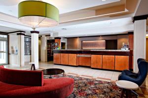 eine Lobby eines Hotels mit einer roten Couch und Stühlen in der Unterkunft Marriott Fairfield Sudbury in Sudbury
