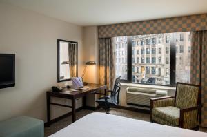 a hotel room with a bed and a desk and a window at Hilton Garden Inn New York/Tribeca in New York