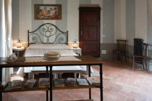 a bedroom with a bed and a table with books at Anna Camere in Montalcino