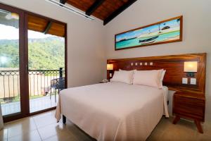 a bedroom with a bed and a balcony at River Park Hotel in Puerto Vallarta +45 photos