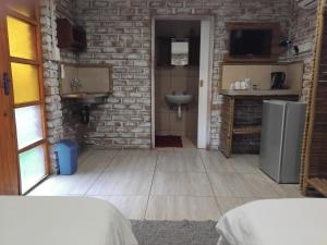 una cucina con un lavello e un muro di mattoni di Corner House Cottages a Grootfontein Altre 19 foto