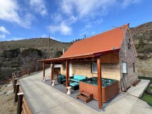 a small house with a hot tub on a deck at Cherry Holiday House in Khandria