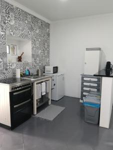 a kitchen with a sink and a stove top oven at O Aconchegadinho in Rabo de Peixe +14 photos