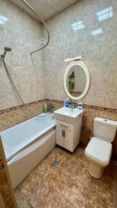 a bathroom with a tub and a toilet and a sink at Friends Premium HOSTEL in Baku