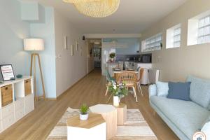 ein Wohnzimmer mit Sofa und Tisch in der Unterkunft Le Bord de Mer - Vue Mer - Terrasse - Parking in Le Havre