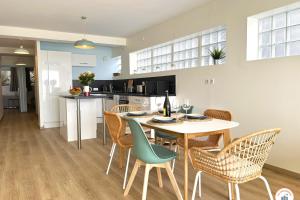 eine Küche und ein Esszimmer mit Tisch und Stühlen in der Unterkunft Le Bord de Mer - Vue Mer - Terrasse - Parking in Le Havre
