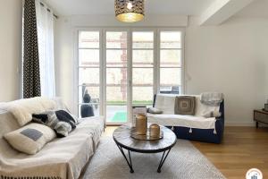 a living room with a couch and a table at The Garden House - Jardin Parking Hypercentre in Deauville +43 photos