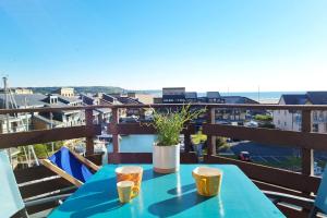 une table bleue avec deux tasses sur un balcon dans l'établissement La Marina - Vue Mer - Plage - Marina et Casino, à Deauville 30 autres photos