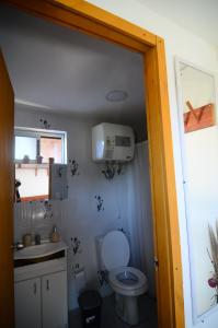 a small bathroom with a toilet and a sink at Geo in Punta Del Diablo +42 photos