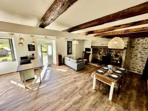 a large living room with a table and a couch at Gîte de France Chez le bassot 3 épis - Gîte de France 6 personnes MAE-1461 in Monceaux-sur-Dordogne