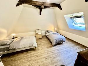 a bedroom with two beds and a wooden floor at Gîte de France Chez le bassot 3 épis - Gîte de France 6 personnes MAE-1461 in Monceaux-sur-Dordogne