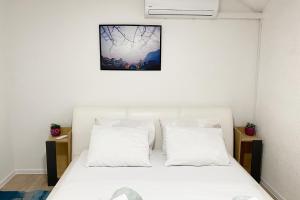 a bedroom with a white bed with two pillows at Farah Apartment in Mostar