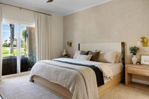 a bedroom with a bed and a large window at The Sunset Hideaway by Roav Retreats in Cathedral City +49 photos