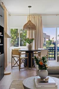 a living room with a dining room table and a dining room at The Sunset Hideaway by Roav Retreats in Cathedral City