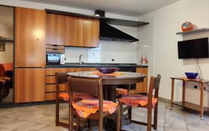 a kitchen with a table and chairs in a room at Cà da Nello in Pellizzano