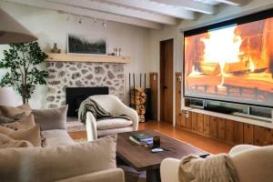 ein Wohnzimmer mit einem großen Flachbildfernseher in der Unterkunft Lily Rock Cottage by Roav Retreats in Idyllwild