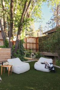 einen Hinterhof mit zwei Sitzsäcken, einem Tisch und Bäumen in der Unterkunft Lily Rock Cottage by Roav Retreats in Idyllwild