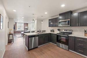 eine Küche mit schwarzen Schränken und Edelstahlgeräten in der Unterkunft Roav Stays - J and K Luxury Apartment 304 in Spokane