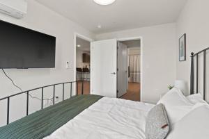 ein Schlafzimmer mit einem großen Bett und einem Flachbildfernseher in der Unterkunft Roav Stays - J and K Luxury Apartment 304 in Spokane