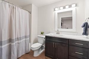 ein Badezimmer mit Toilette, Waschbecken und Spiegel in der Unterkunft Roav Stays - J and K Luxury Apartment 304 in Spokane + 15 Fotos