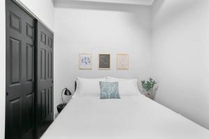 a bedroom with a white bed and a black door at Upscale Apartment Suite - Close to Everything in Spokane