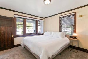 una camera da letto con un grande letto bianco e finestre di Quaint South Hill Home w Luxury King Bed and Wifi a Spokane