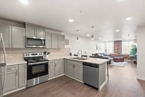a kitchen with stainless steel appliances and a living room at Spacious, King Bed, w Pool Table & Brunch Below! 303 in Spokane
