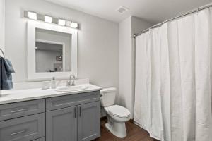 a white bathroom with a toilet and a sink at Spacious, King Bed, w Pool Table & Brunch Below! 303 in Spokane +18 photos