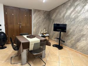 een eetkamer met een tafel en een flatscreen-tv bij Alvina's House in Aosta