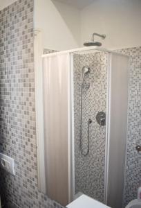 Un baño con ducha con puerta de cristal. en The Luxury Roma Amor, en Roma
