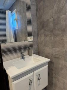 a bathroom with a white sink and a mirror at Le bleu délavé in Sfax +12 photos