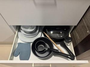 a drawer with dishes and utensils in a kitchen at Le bleu délavé in Sfax