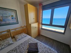 a bedroom with a bed and a large window at Playa apartamento in Torrevieja