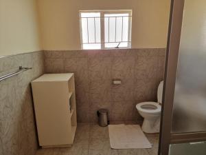 a bathroom with a toilet and a window at Hideout in Highlands in Harare +12 photos