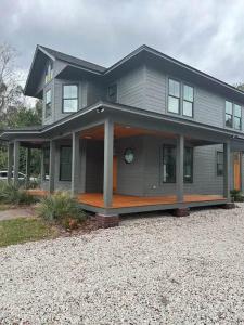 a large house with a large porch on a driveway at Gator Grove - Queen Ann Grey - New Build! in Gainesville