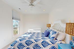 Un dormitorio con una cama con un edredón azul y blanco. en Soundside Serenity, en Atlantic Beach