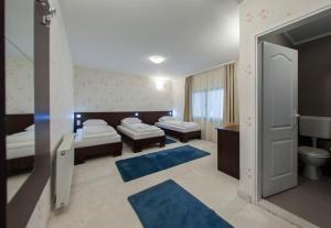 a bedroom with two beds and a bathroom with a toilet at Hotel Hayat Hills in Sarajevo