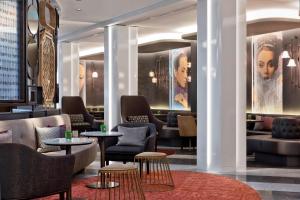 una hall di un hotel con tavoli e sedie di Renaissance Vienna Schönbrunn Hotel a Vienna