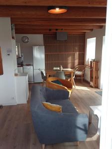 a living room with a blue couch and a table at Gîte La Béate des Arnauds in Tiranges +3 photos