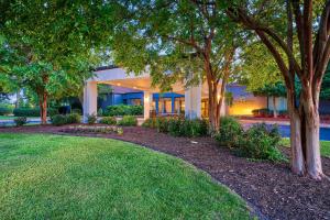 ハンプトンにあるCourtyard Hamptonの芝生と木々が目の前の家