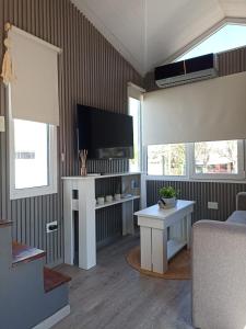サン・ペドロにあるTiny Housesのソファとテレビのあるリビングルーム