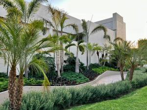 a resort with palm trees in front of a building at Casa Begonias Hotel mas Villas in Jiutepec