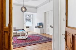 a living room with a table and a rug at Gründerzeit Domizil Altbau Neu in Wuppertal