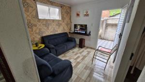 a living room with a blue couch and a table at Casa de 2 quartos em Areias in Areias